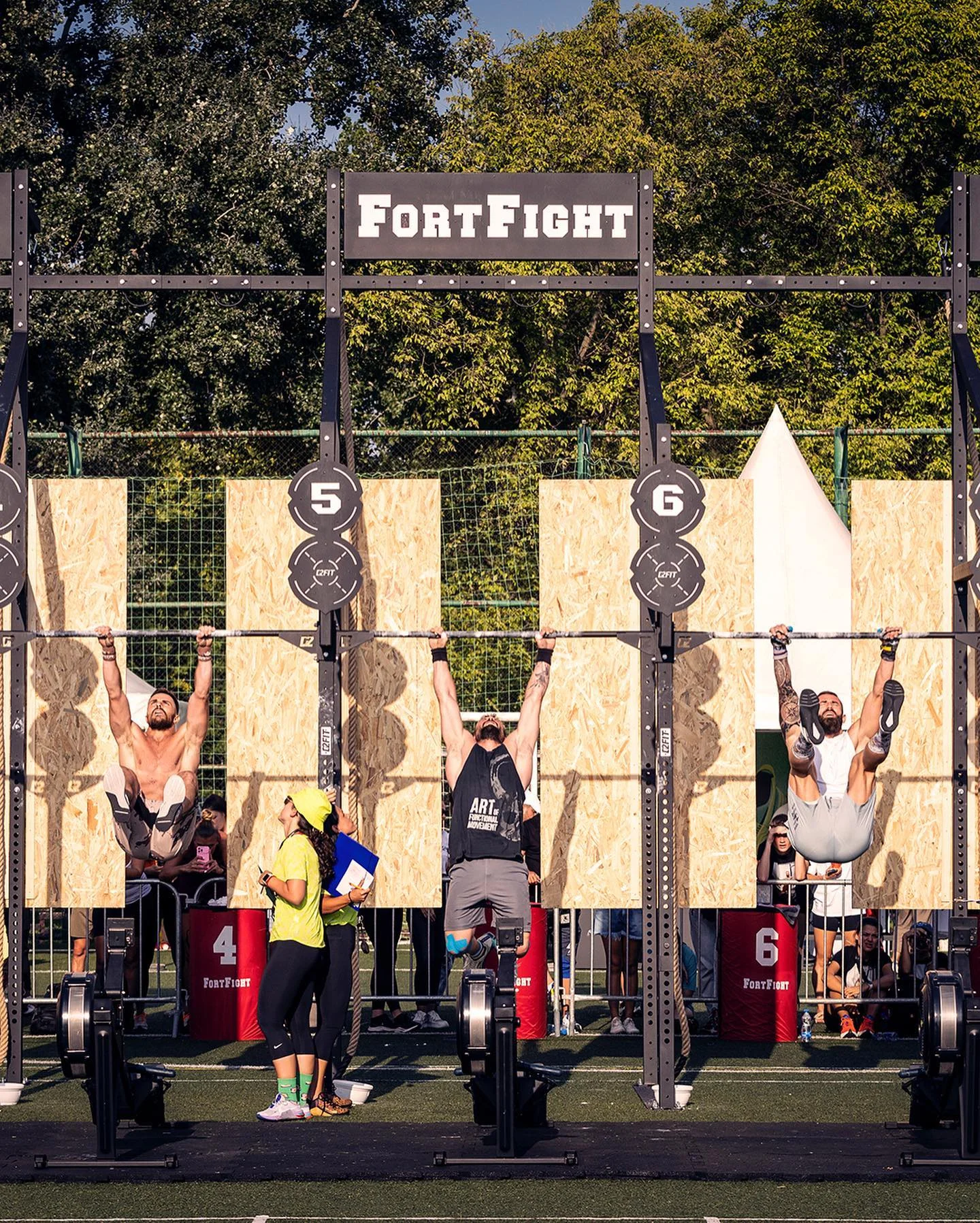 Athletes competing on the pull-up rig with judges watching at Nike Metcon FortFight