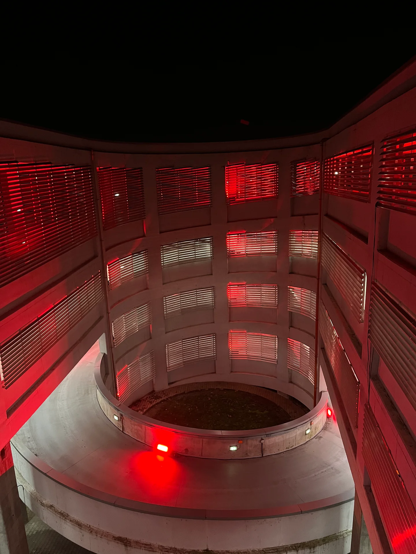 Spiral concrete parking ramp illuminated in red for Nike Midnight Run in Bucharest