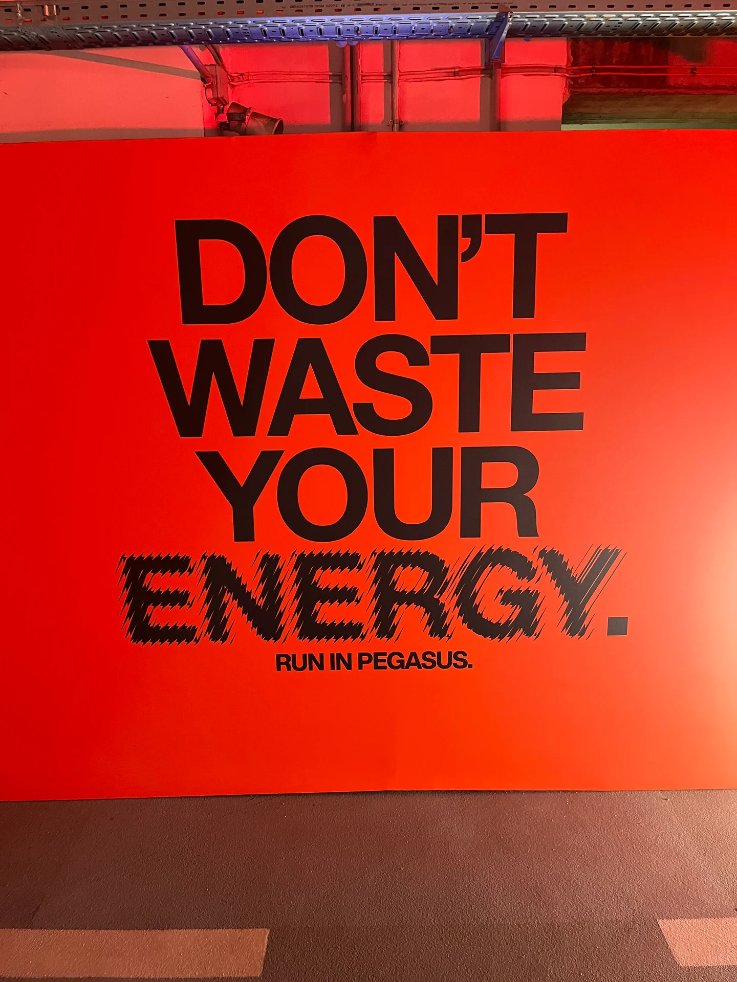 Nike Pegasus campaign sign reading "Don't waste your energy. Run in Pegasus." at Nike Midnight Run